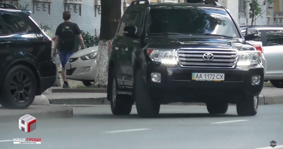 По городу Семочко передвигается на черном Ленд Крузере с номерами прикрытия.