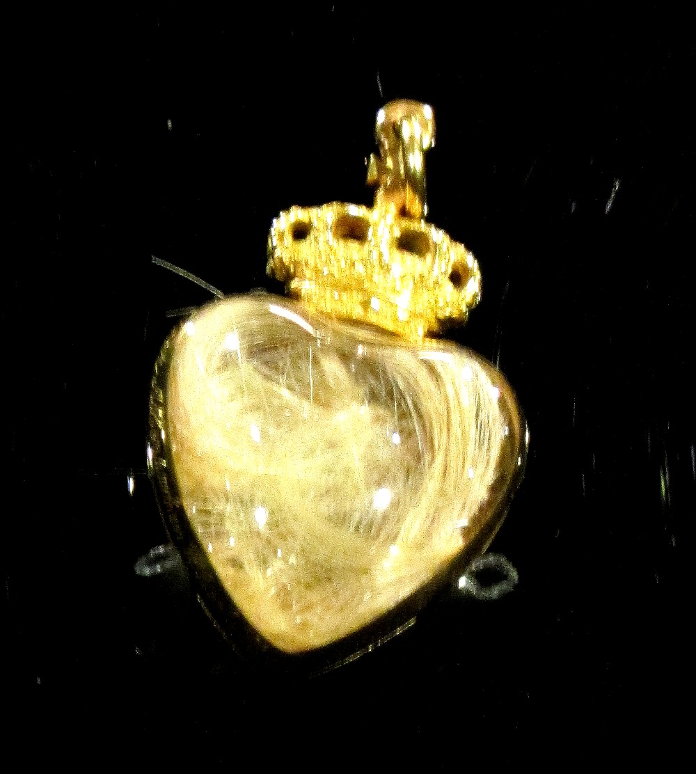 Медальон в виде сердца, который содержит волосы Альберта