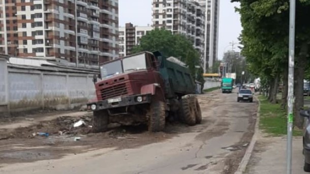 В Киеве в яме посреди дороги застрял грузовик с песком