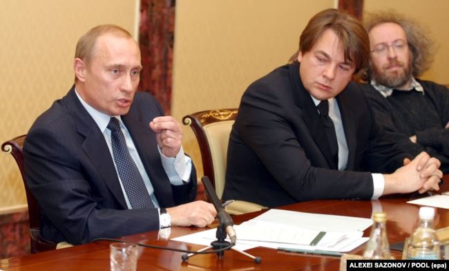  Президент Росії Володимир Путін (ліворуч) під час зустрічі з лідерами російських ЗМІ. Поруч: директор телеканалу ОРТ Костянтин Ернст (посередині) і керівник «Еха Москви» Олексій Венедиктов (праворуч). Москва, 25 листопада 2002 року 