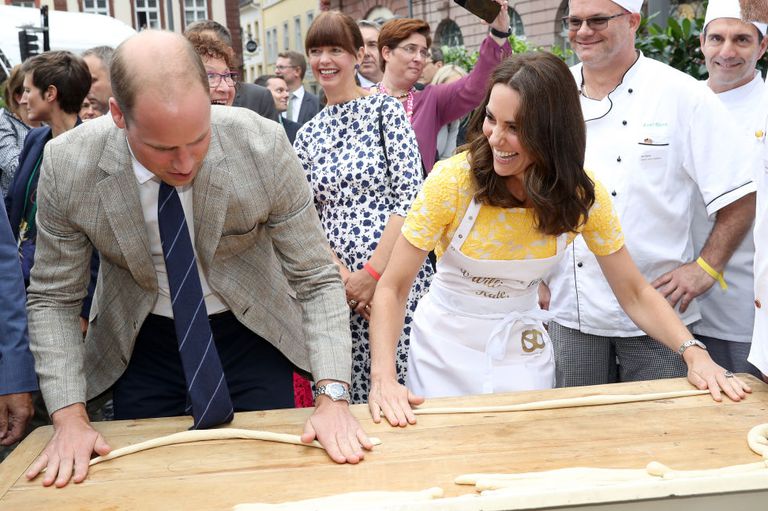 Принц Уильям, герцог Кембриджский, и Кэтрин, герцогиня Кембриджская, пытаются сделать крендели во время посещения традиционной ярмарки в Гейдельберге, Германия, 20 июля 2017 года.