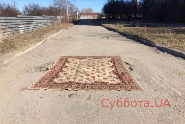 В Запорожье дорожную яму прикрыли ковром