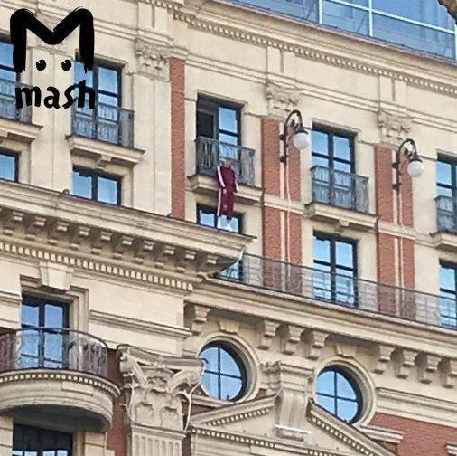 С балкона отеля Ритц Карлтон в центре Москвы свисает мужское тело
