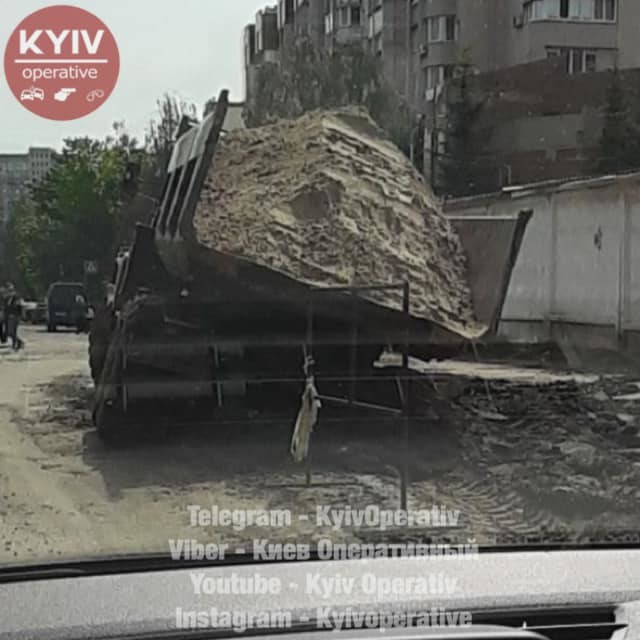 В Киеве в яме посреди дороги застрял грузовик с песком
