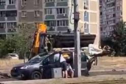 В Киеве экскаватор ударил ковшом по крыше автомобиля (видео)