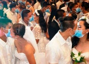 На филиппинской массовой свадьбе пары целовались в защитных масках    